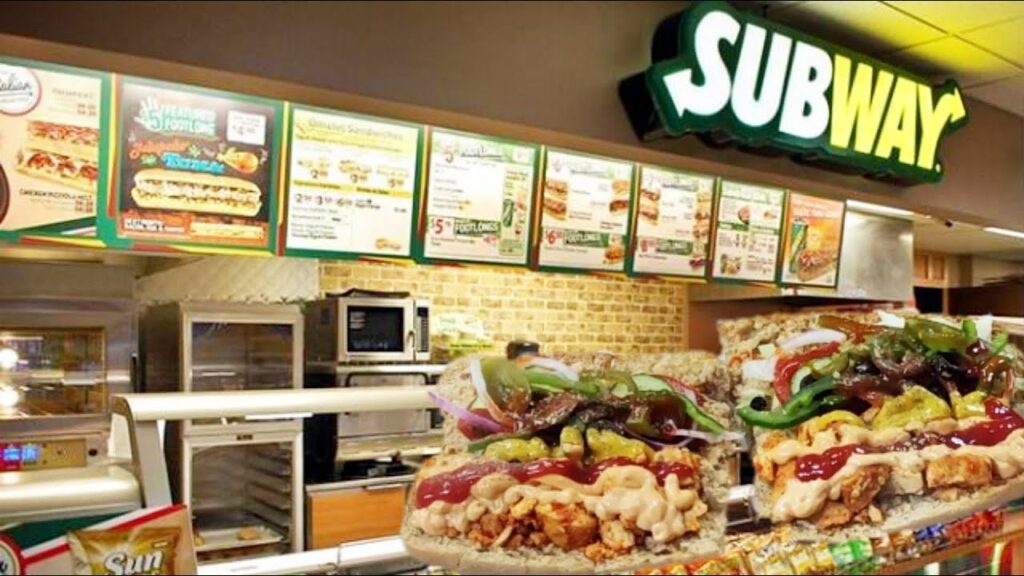 A Subway store with the deli set-up and fresh sandwiches. 