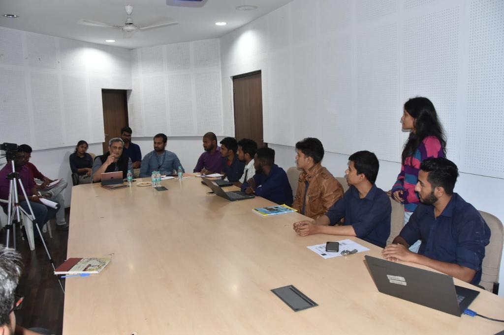 Shashikant Chaudhary in a presentation cum mentoring session for incubated startups of GHRCE. Shashikant sits at the head of a conference table surrounded by young entrepreneurs. 