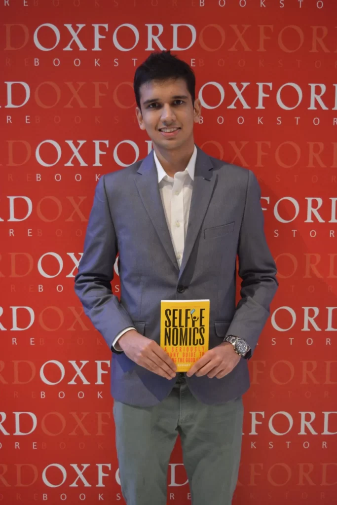 Revant Himatsingka standing with his book Selfinomics in the Oxford Bookstore. 