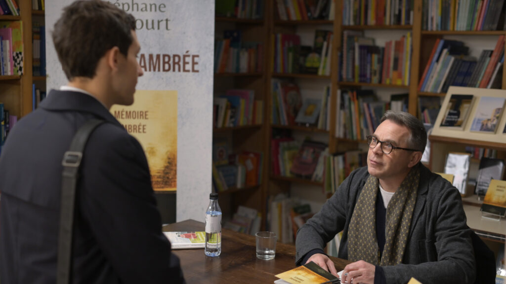 Philippe Besson's character at a book signing event with a young man standing in front